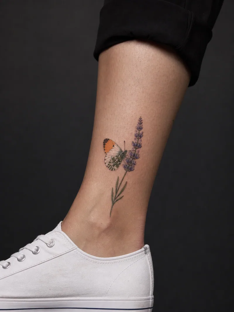 Butterfly lavender tattoo - An orange-tip butterfly rests naturally on a lavender stem.