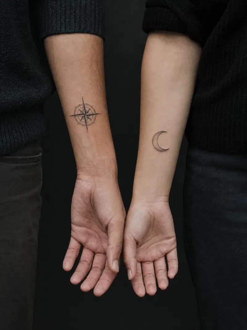 Matching compass and moon tattoos on two forearms