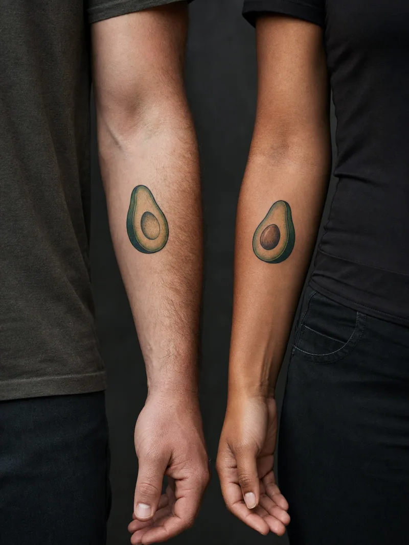 Avocado couple tattoos - Two avocado halves differ by the seed while sharing one bold style.
