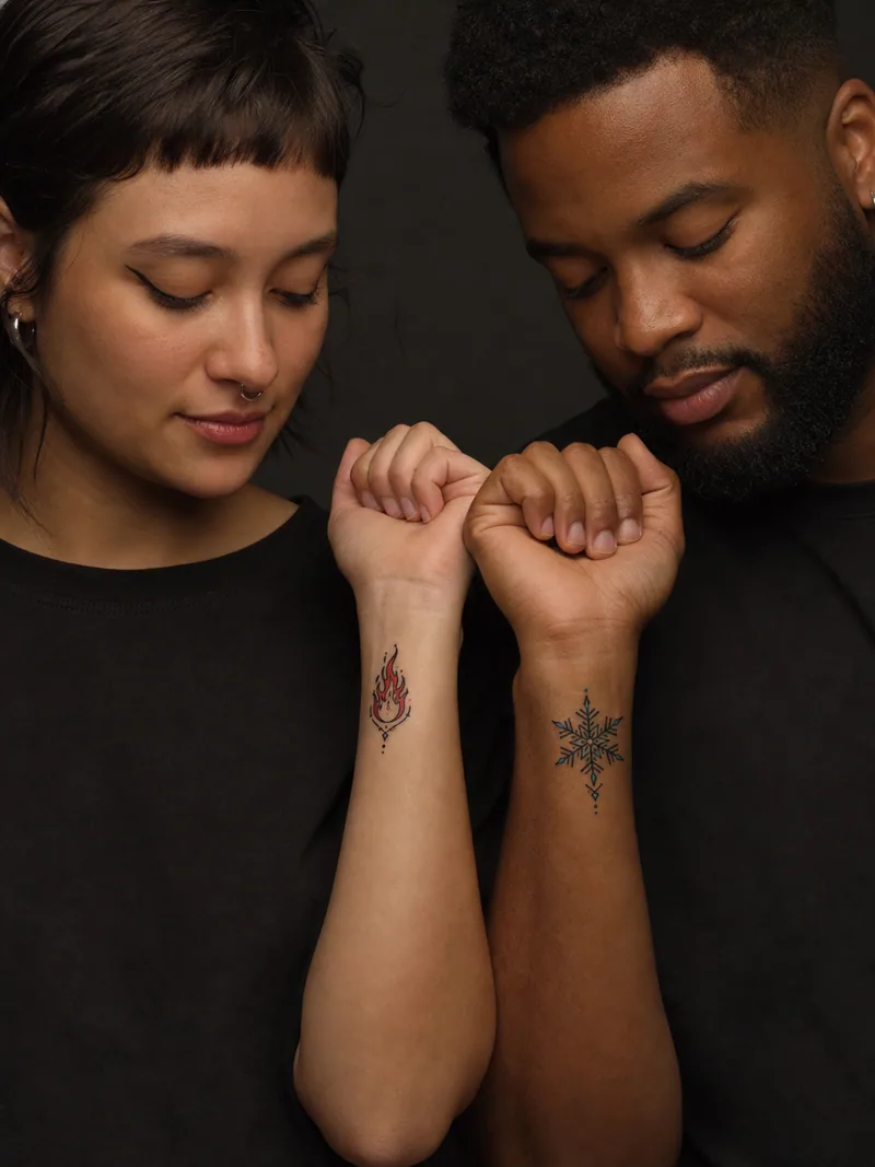Fire and ice tattoos - A warm flame contrasts with a crisp ice crystal under one shared outline weight.