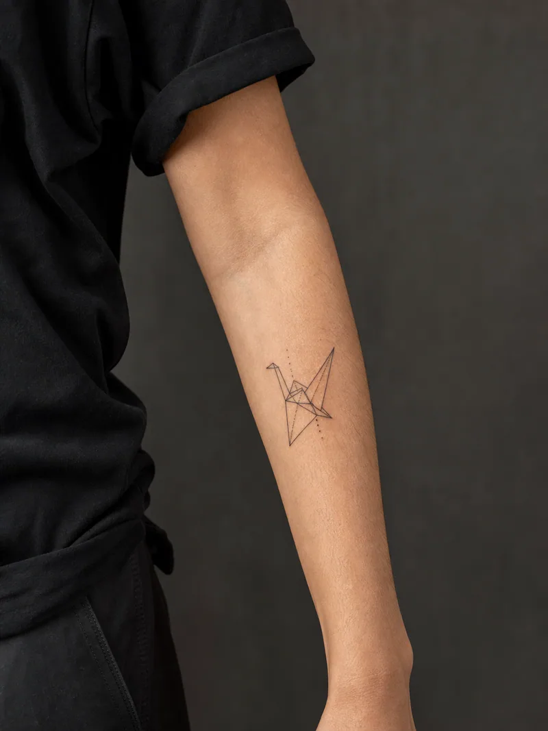 Geometric crane tattoo - Simplified angular wings keep a flying crane light and readable.