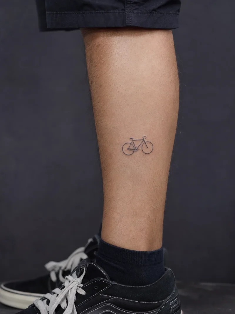 Tiny bicycle tattoo - A simplified bicycle keeps its frame and wheels readable at small scale.