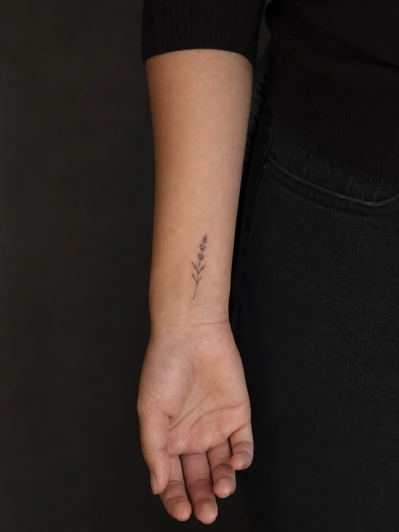 Minimal lavender tattoo - A slim lavender sprig keeps three quiet violet buds and ample spacing.