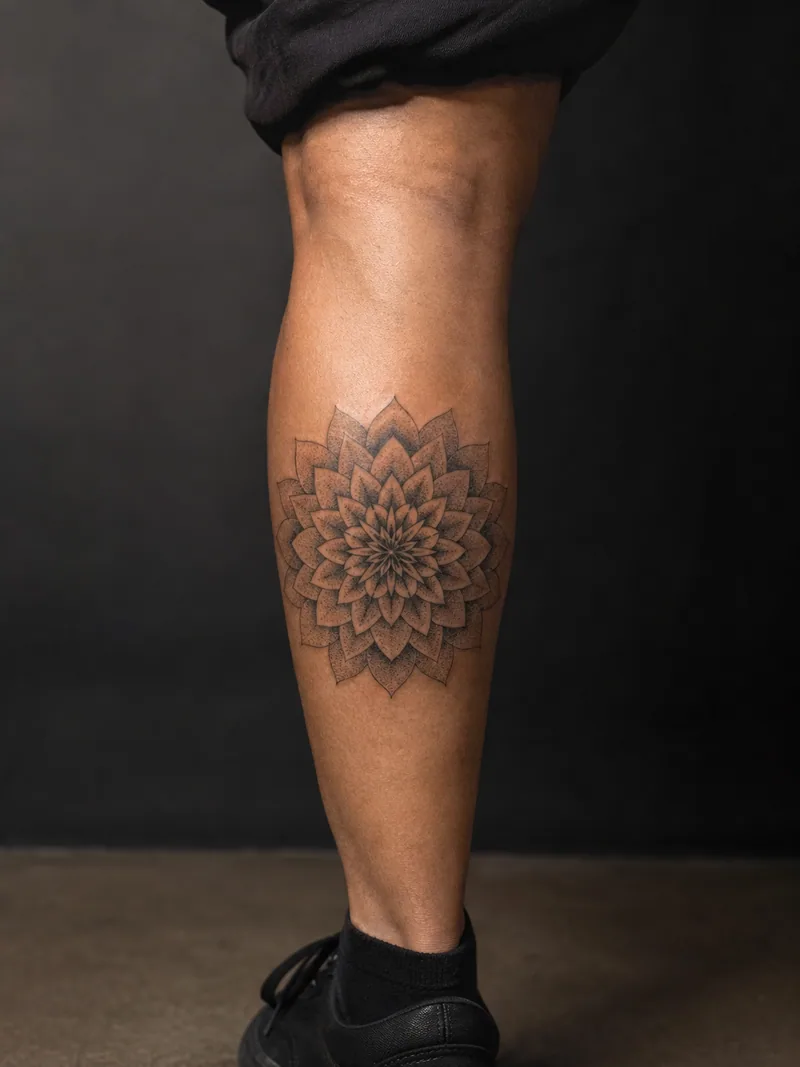 Geometric dahlia tattoo - Radial dahlia petals create a precise circular pattern with dotted depth.