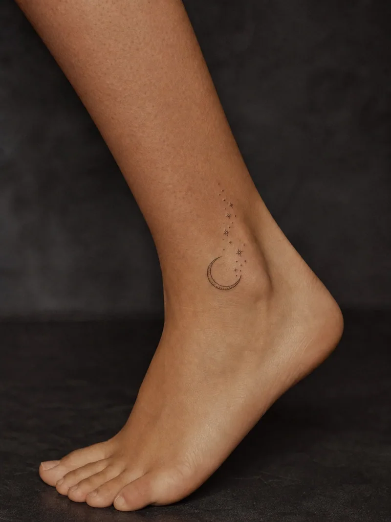 Moon ankle tattoo - small crescent moon with a delicate vertical trail of stars