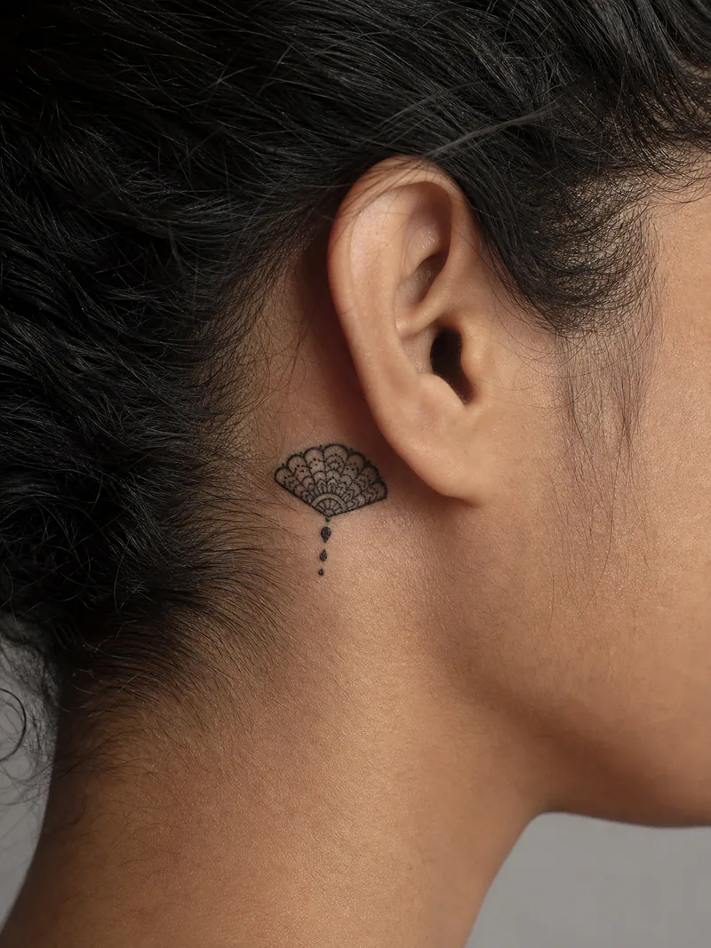 Ornamental behind ear tattoo - small filigree fan finished with three delicate dotwork drops