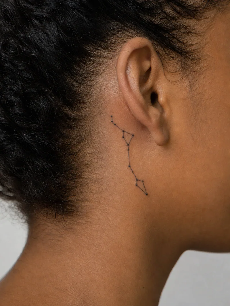 Constellation behind ear tattoo - tiny points connected by fine lines in a vertical celestial pattern