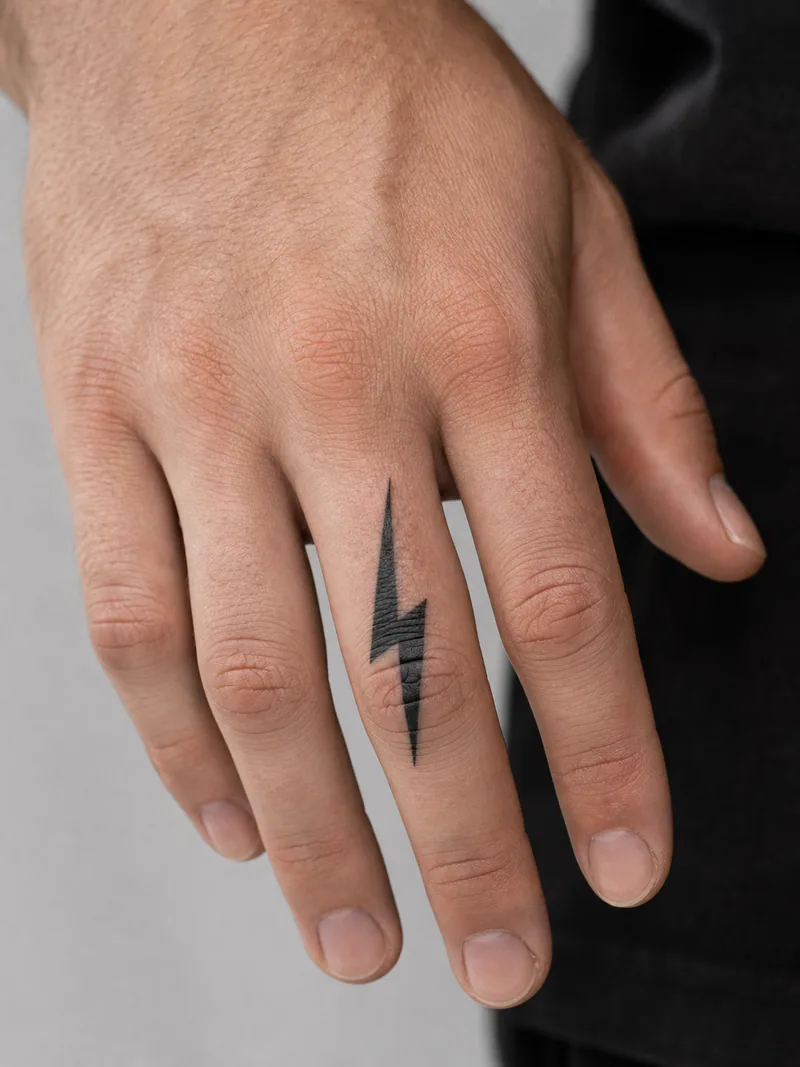 Lightning finger tattoo - bold graphic lightning bolt with a narrow negative-space cut
