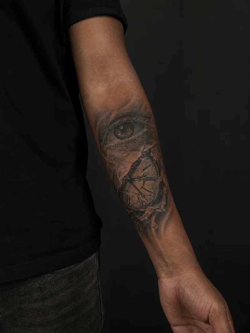 Eye and clock forearm tattoo - realistic eye above fragments of an antique clock