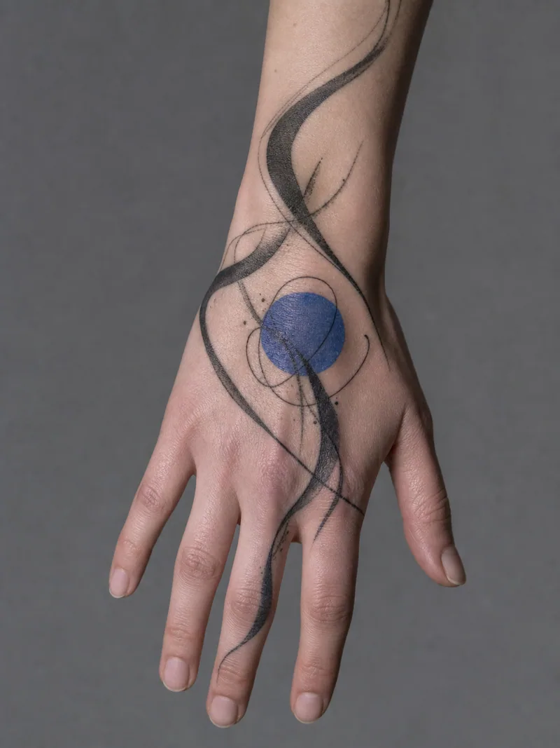 Abstract blue circle hand tattoo - sweeping black ribbons orbiting one restrained cobalt-blue circle
