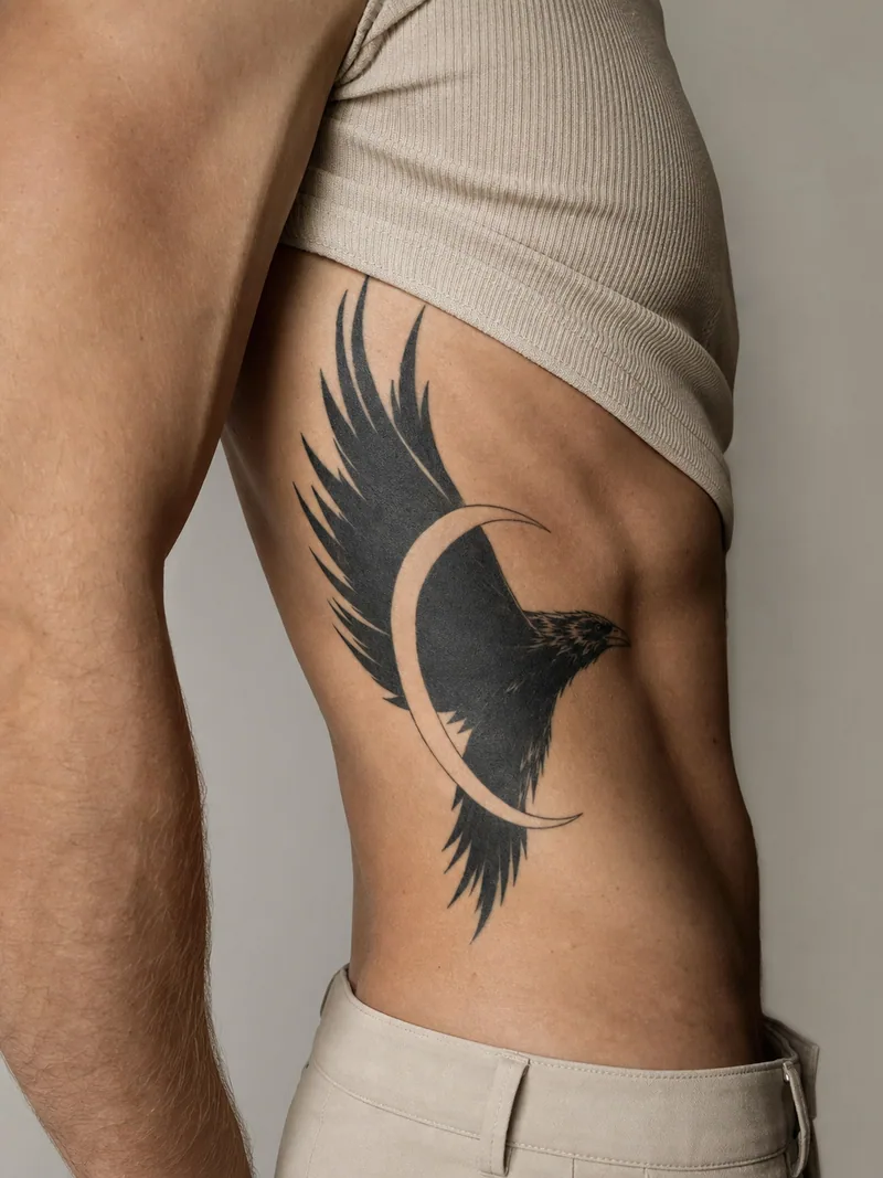 Raven rib tattoo - raven in flight with angular wings and a crescent of negative space