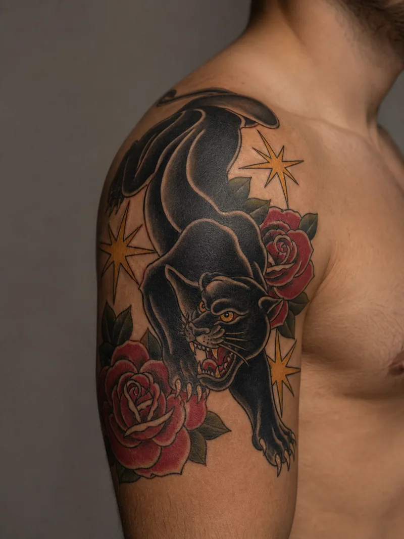 Panther shoulder tattoo - crawling black panther surrounded by red roses and golden starbursts