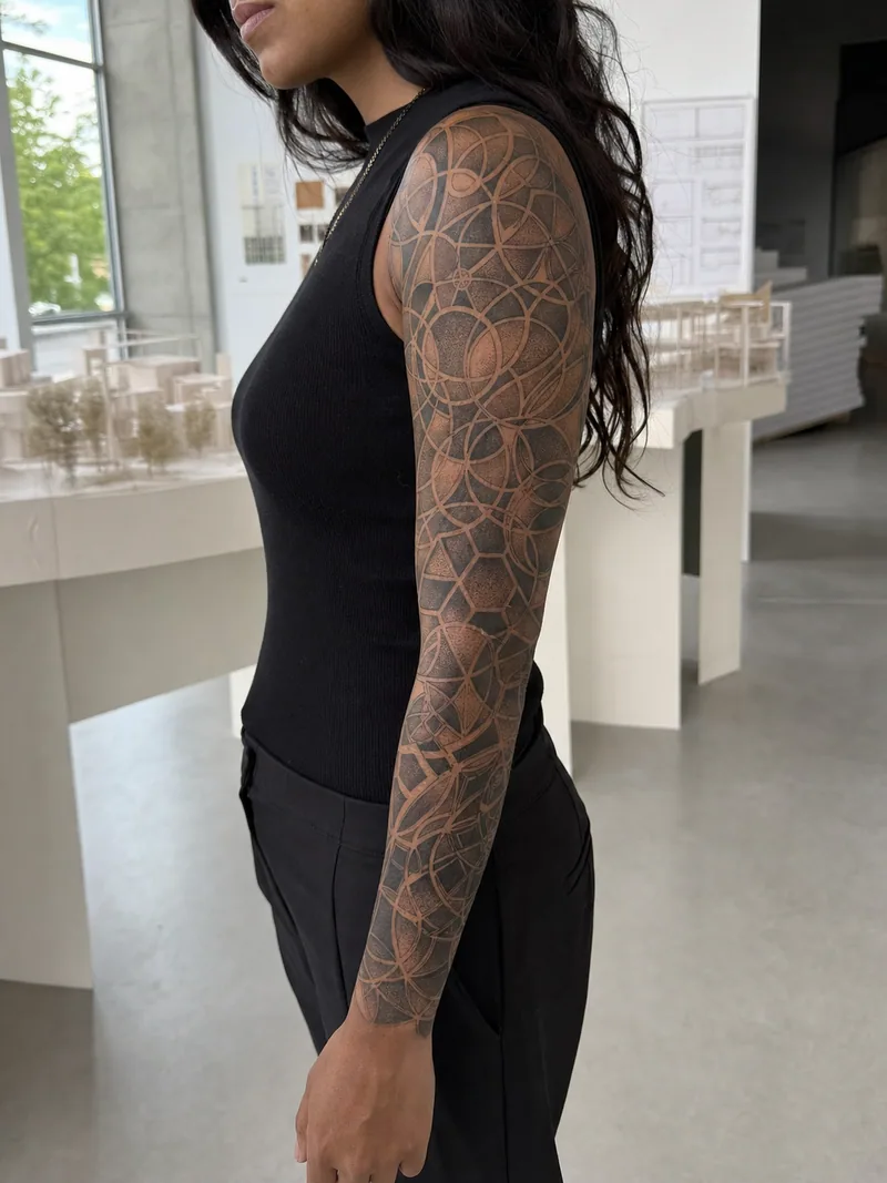 Geometric dotwork sleeve tattoo - interlocking circles, hexagons and dotwork gradients aligned to the arm