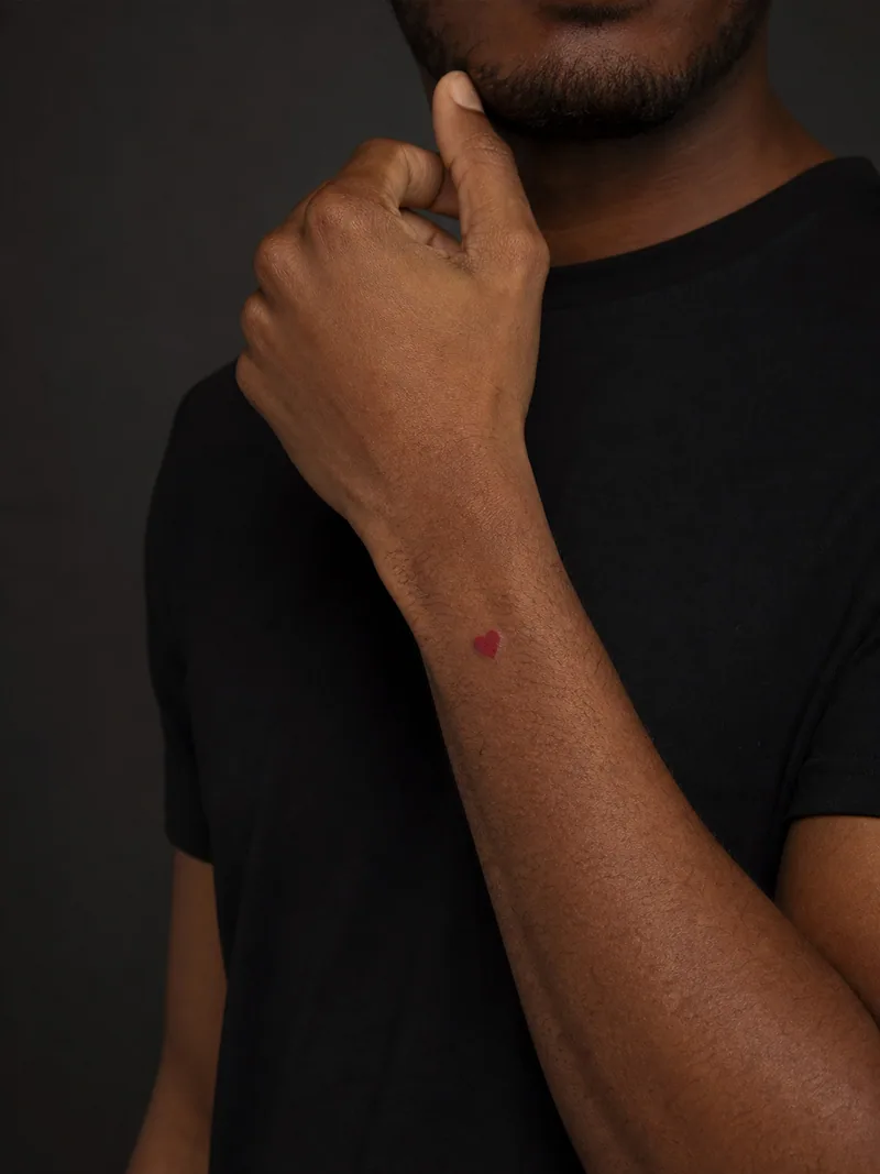 Tiny heart tattoo - small solid red heart above the inner wrist crease