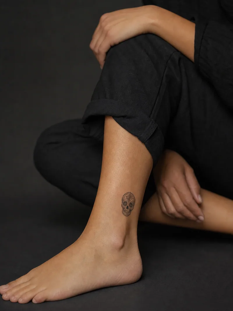 Small skull tattoo - decorative non-graphic skull placed above the ankle