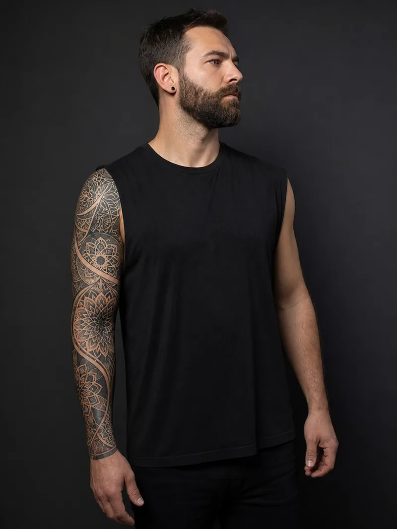 Ornamental sleeve tattoo - Repeating arcs and floral geometry create rhythm around the arm.