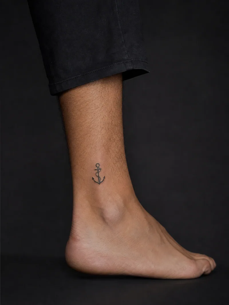 Minimal anchor tattoo - A spare anchor and short rope loop fit neatly above the ankle.