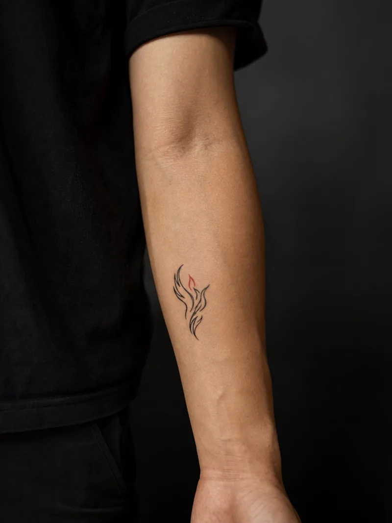 Tiny phoenix tattoo - A rising phoenix becomes a clear flame-shaped outline with one red accent.