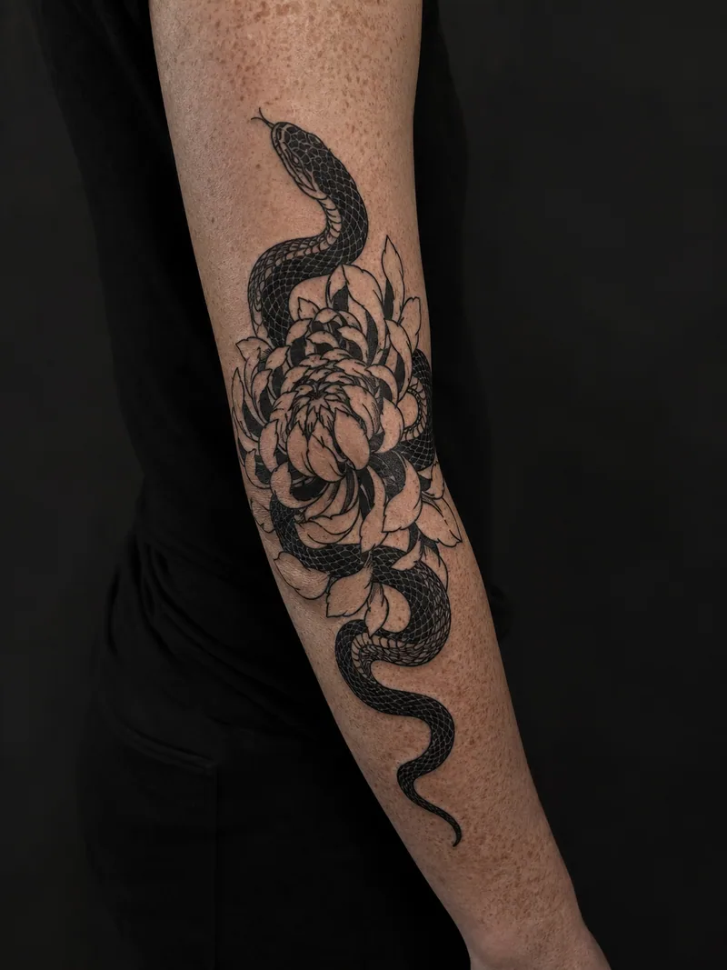 Snake and chrysanthemum tattoo - a snake weaving through open chrysanthemum petals