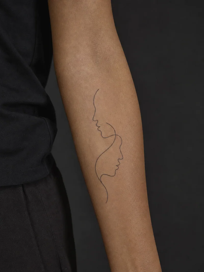 Abstract faces tattoo - two overlapping face profiles drawn with balanced continuous contours