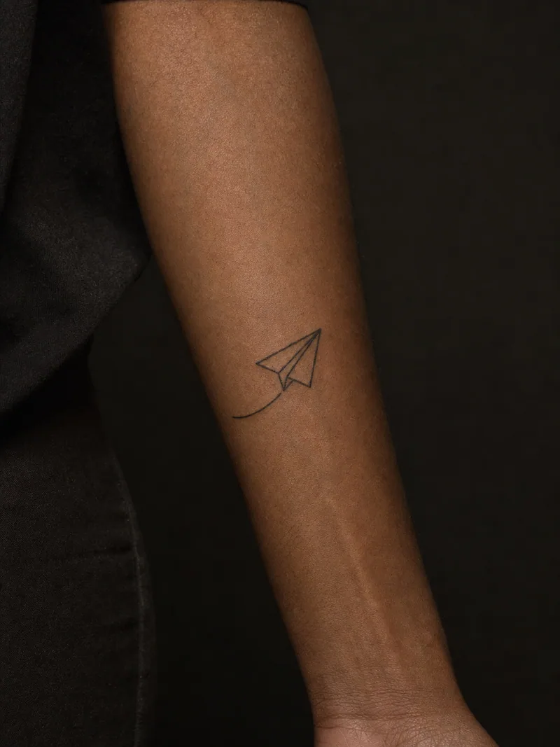Paper plane tattoo - a paper airplane made from four crisp lines and one short flight path