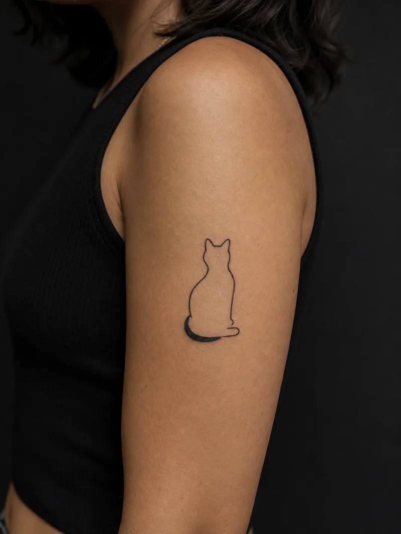 Minimal cat tattoo - a seated cat silhouette built from one continuous contour and a curved tail