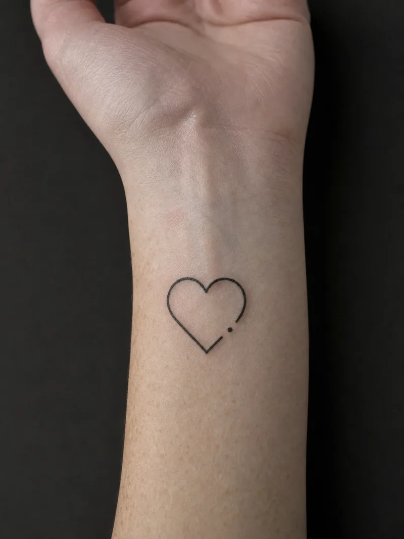 Minimal heart tattoo - an open heart outline interrupted by one small dot at its base