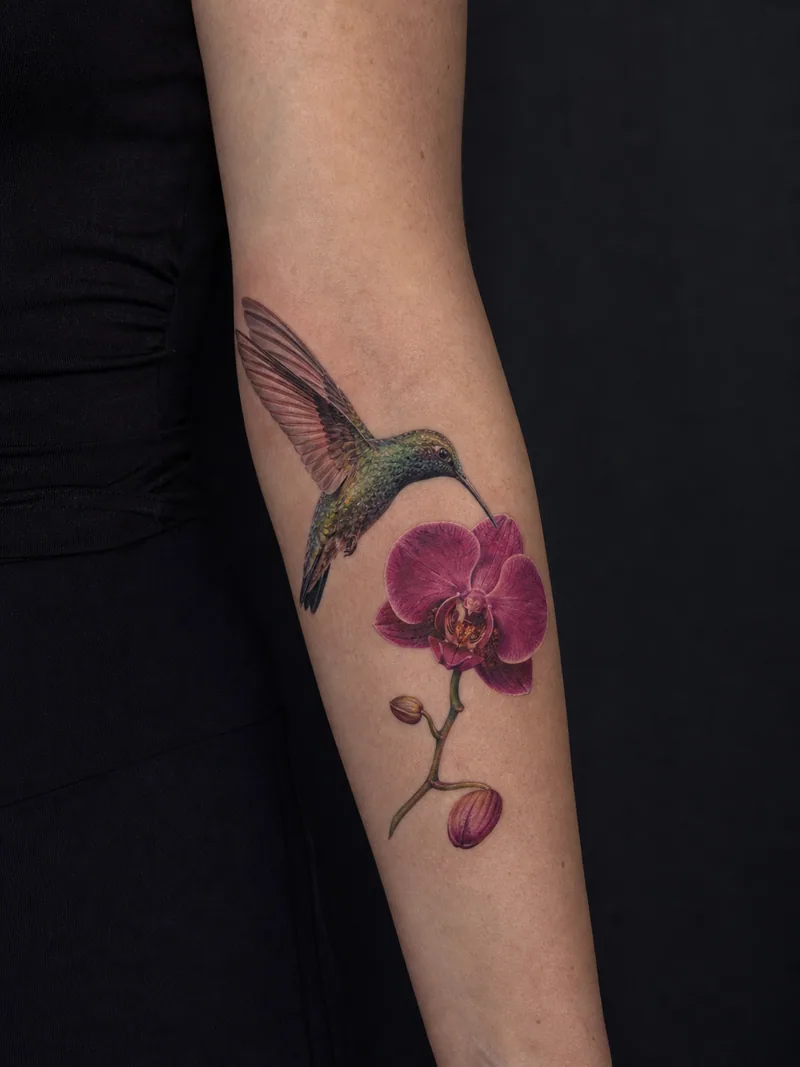 Hummingbird and orchid tattoo - an iridescent hummingbird hovering beside a magenta orchid