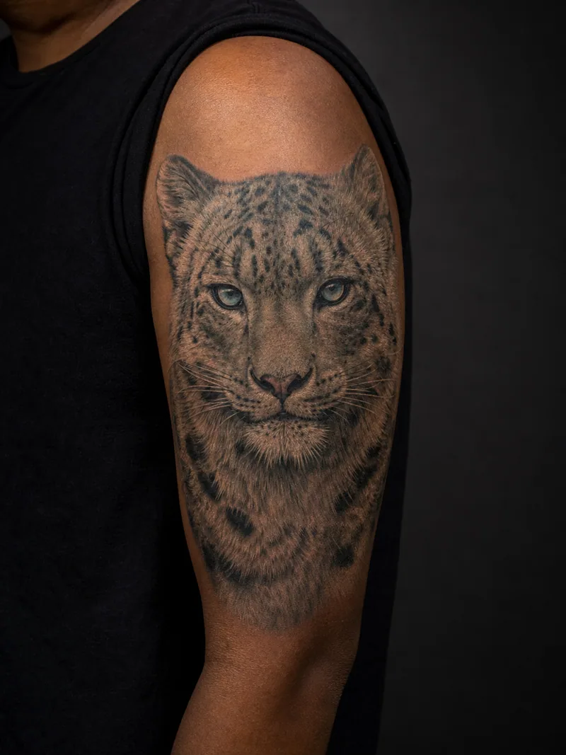 Snow leopard tattoo - a snow leopard portrait with pale fur and icy blue eyes