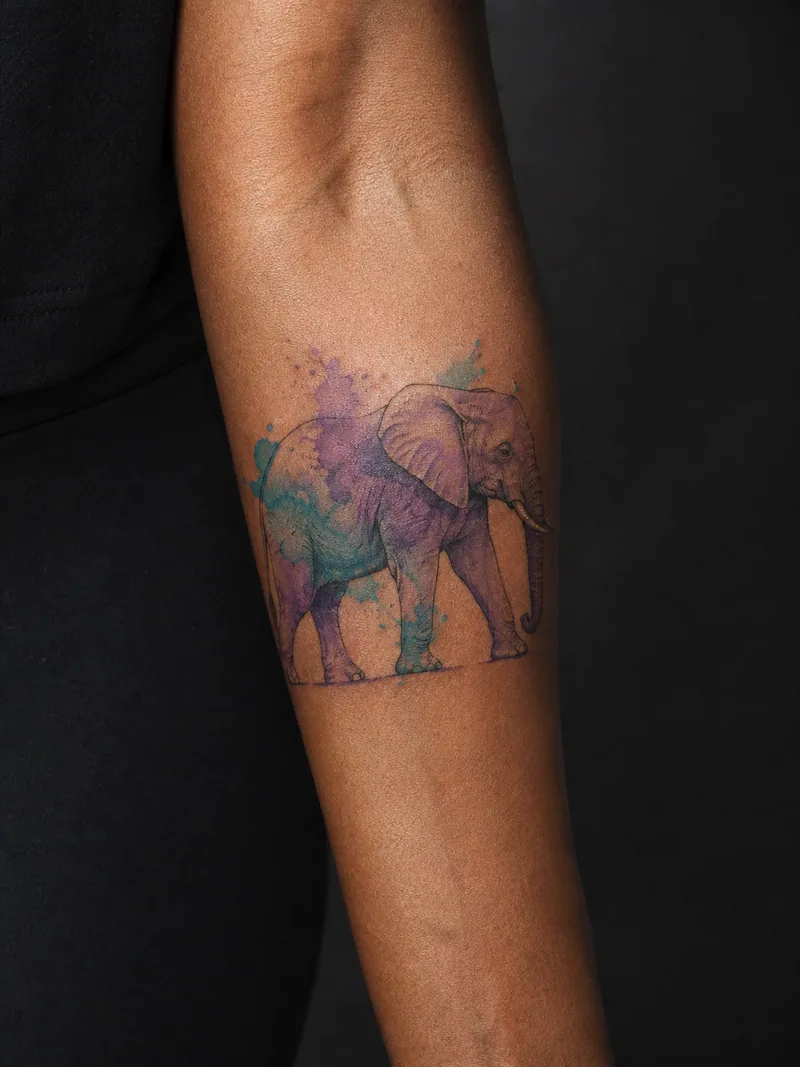 Watercolor elephant tattoo - an elephant profile built from loose washes and one crisp eye