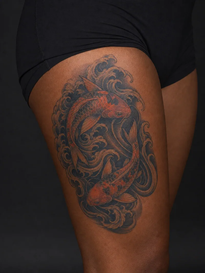 Koi and wave tattoo - two koi moving through deep indigo waves in a balanced composition