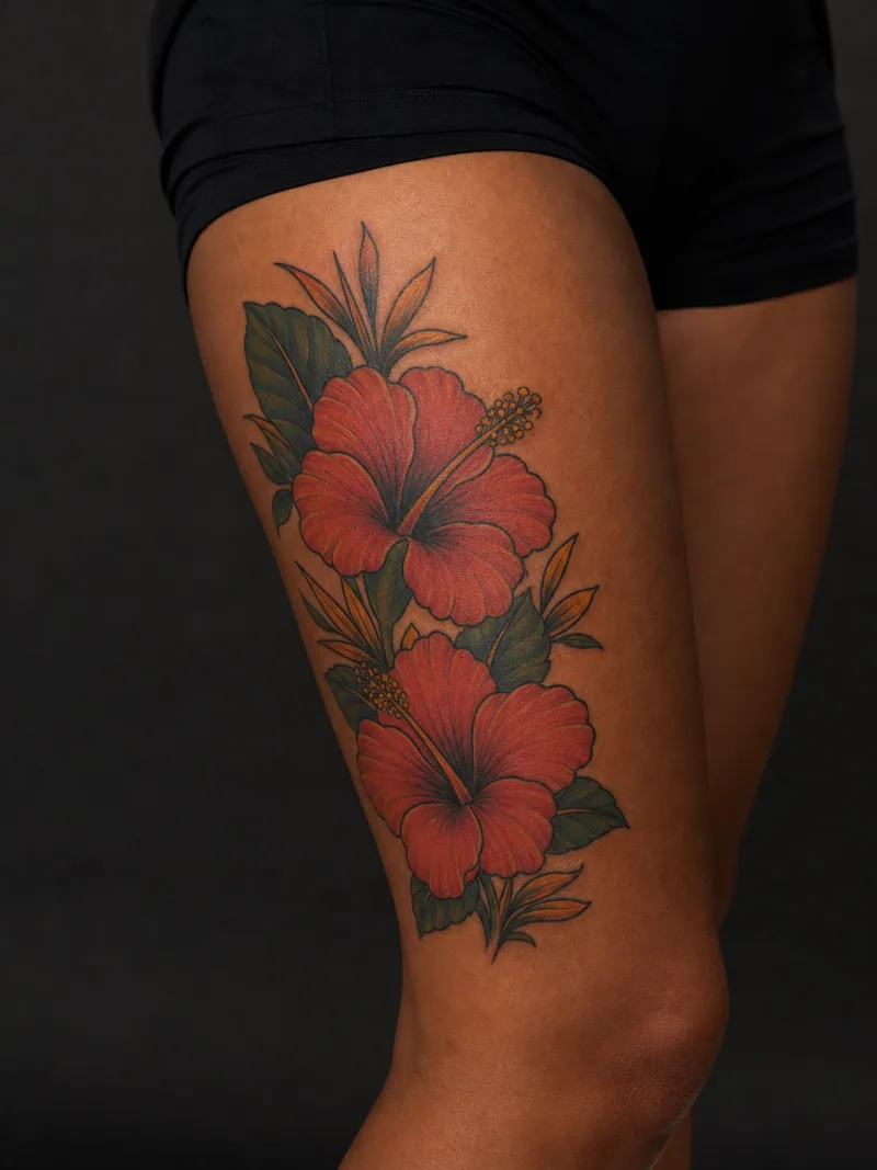 Hibiscus thigh tattoo - two bold hibiscus flowers with tropical leaves and strong outlines