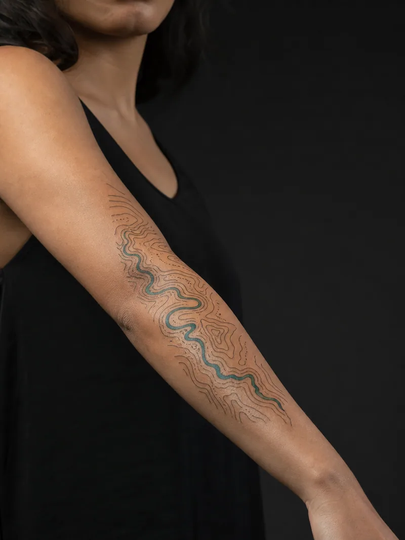 Topographic river tattoo - winding river cutting through precise topographic contour lines