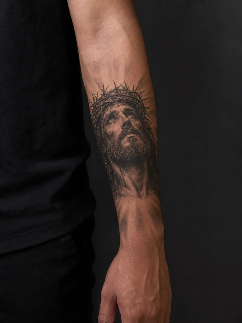 Jesus forearm tattoo - respectful portrait with a crown of thorns and soft upward light