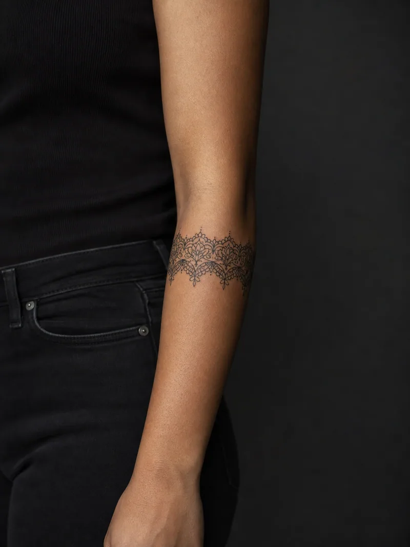 Ornamental bracelet tattoo - A lace-inspired band wraps the forearm with even rhythm and clean edges.